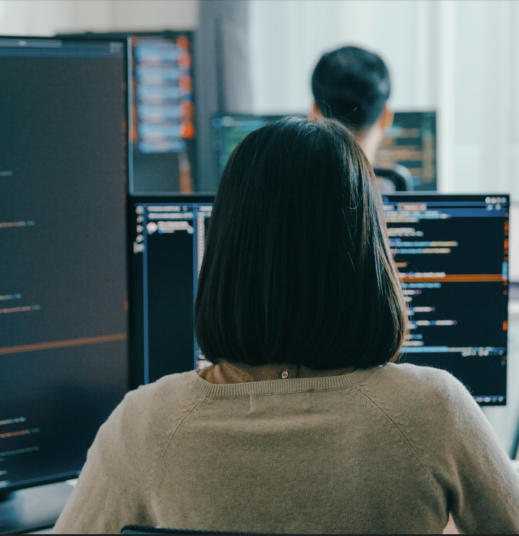 Developer working across two monitors